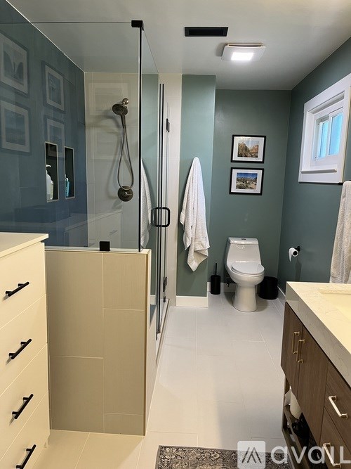 A bathroom with a toilet, sink, and shower.