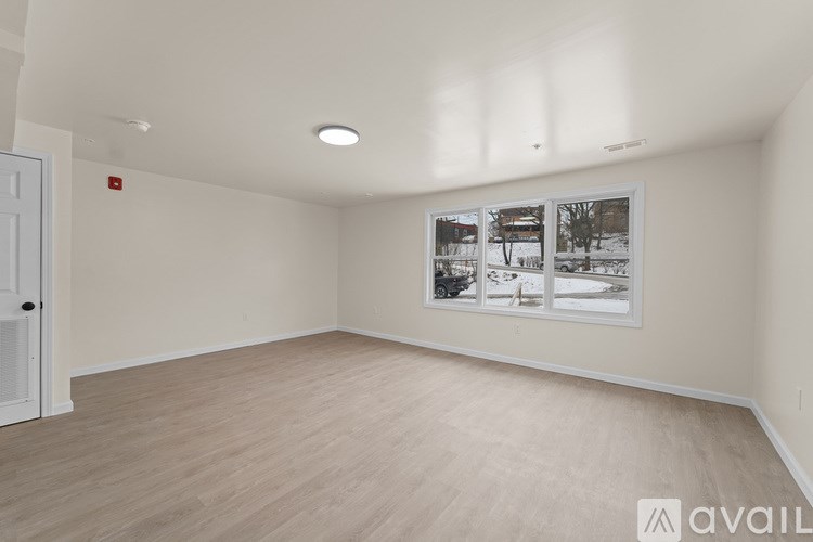 A room with a white door and a picture of a snowy scene on the wall.