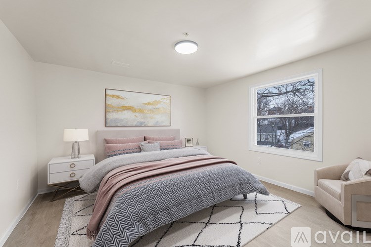 A bedroom with a large bed and a painting on the wall.