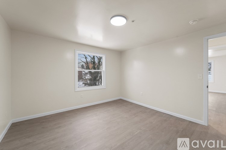A room with a wooden floor and a picture on the wall.
