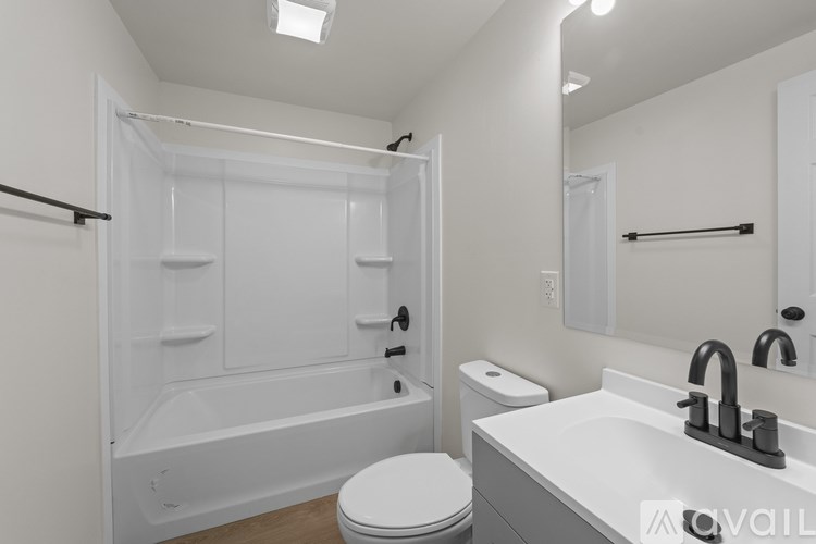 A white bathroom with a toilet, sink, and bathtub.