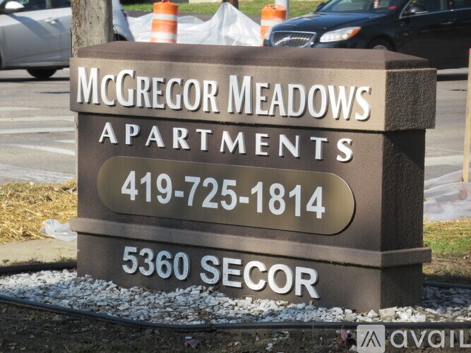 A sign for McGregor Meadows Apartments with a phone number and address.