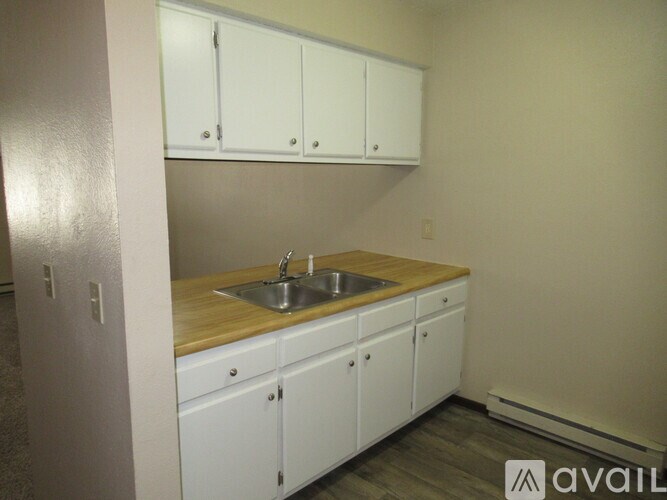 A kitchen with white cabinets and a wooden countertop.