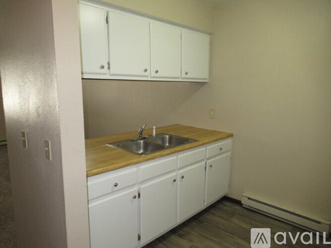 A kitchen with white cabinets and a wooden countertop.