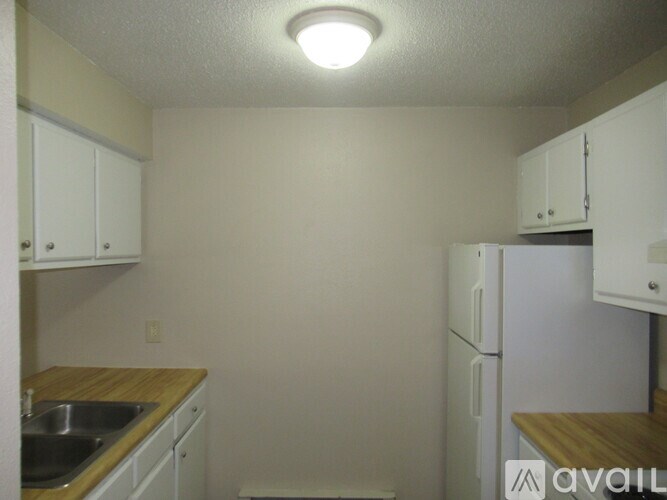 A kitchen with white cabinets and a wooden countertop.