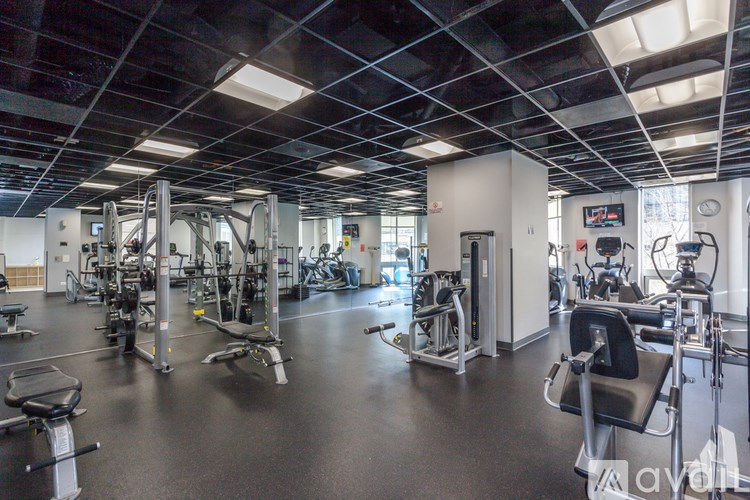 A gym with a variety of equipment including treadmills, weights, and exercise machines.