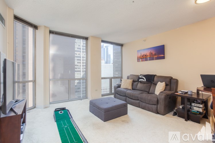 A living room with a grey couch and a green table in front of a window.