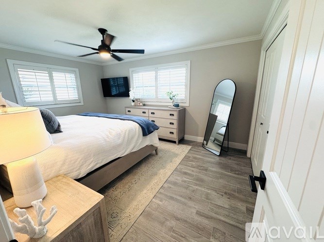 A bedroom with a bed, dresser, and mirror.