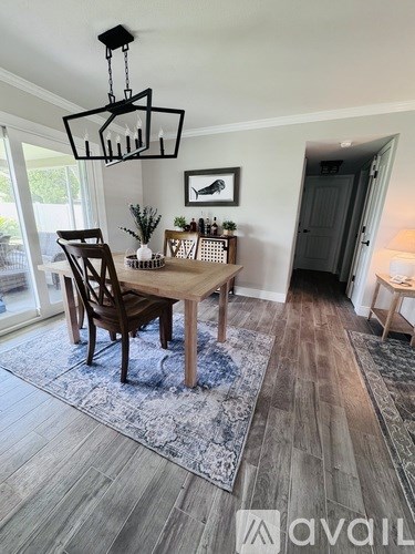 A dining room with a wooden table and chairs.