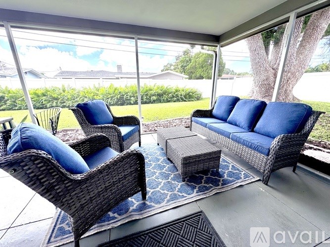 A patio with a couch, chair and table.