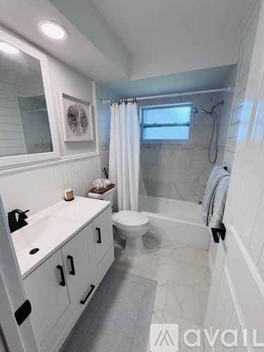 A bathroom with a toilet, sink, and shower.