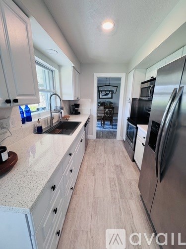 A modern kitchen with stainless steel appliances and white cabinets.