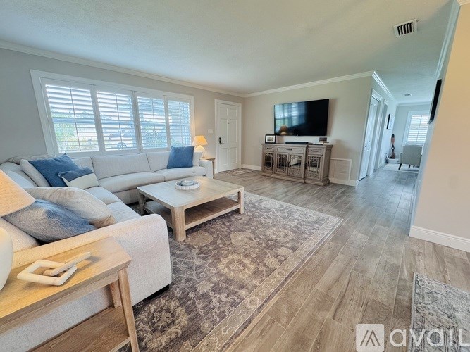 A living room with a couch, coffee table, and television.