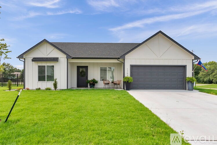 A house with a grey roof and a black garage door.
