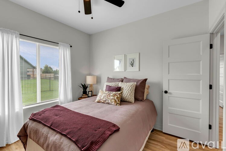 Bedroom with a bed, pillows, and a ceiling fan.
