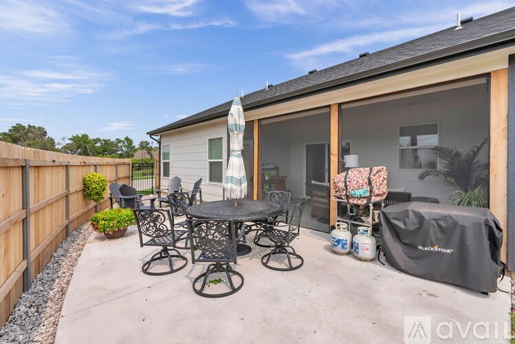 A patio with a table and chairs is set up outside a house.