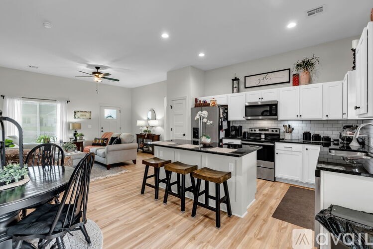 A modern kitchen with white cabinets and a center island.