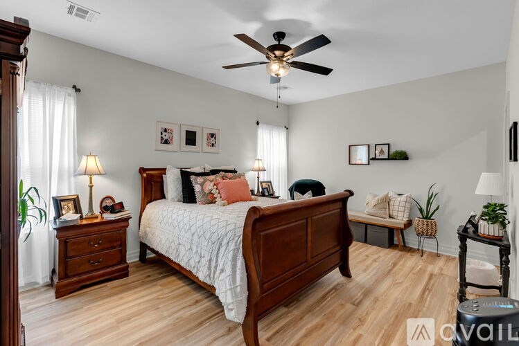 A bedroom with a bed, nightstand, and a ceiling fan.