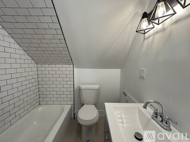 A bathroom with a toilet, sink, and bathtub.