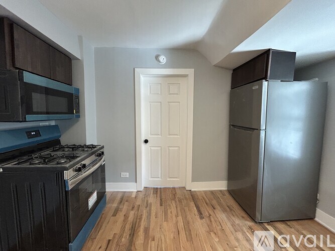 A kitchen with a stove, microwave, and refrigerator.