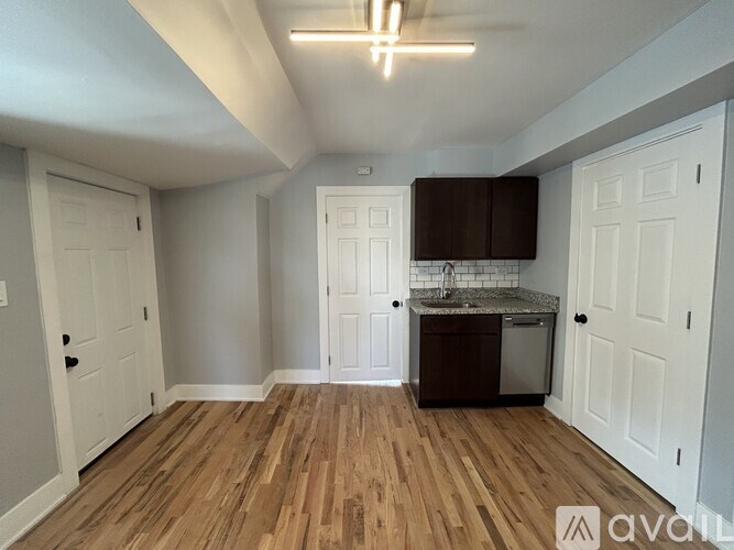 A kitchen area with wooden floors and white walls.