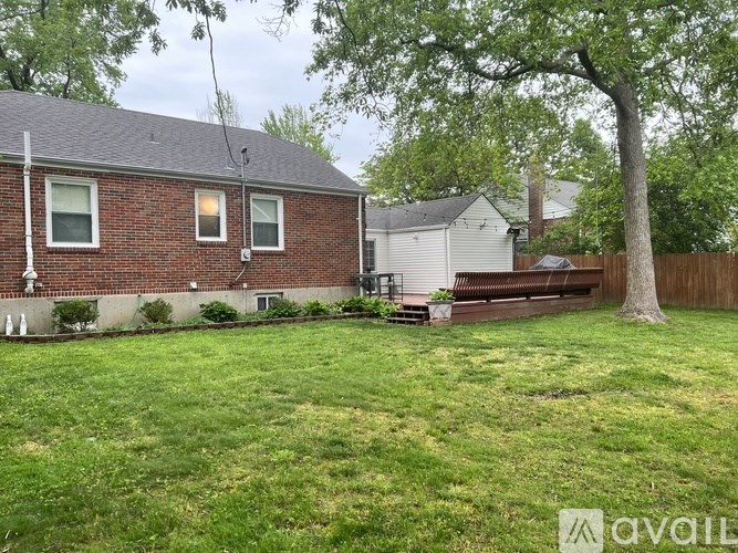 A house with a red brick exterior and a green lawn.