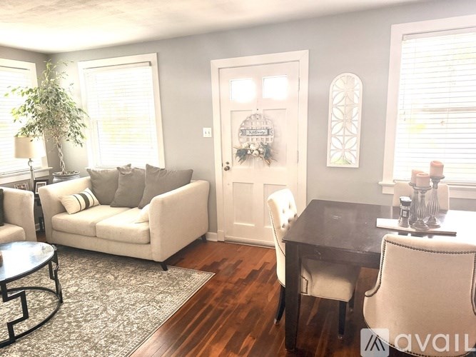 A living room with a couch, chair, and dining table.