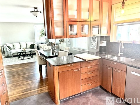 A kitchen with wooden cabinets and a black countertop.