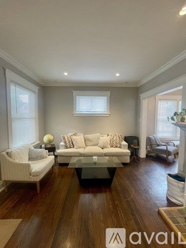 A living room with a white sofa and a glass coffee table.