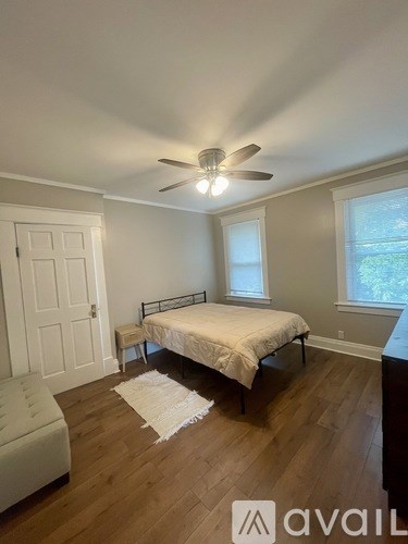 A bedroom with a bed, chair, and window.