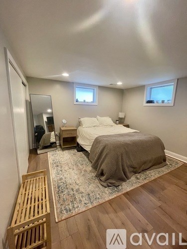 A bedroom with a bed, a mirror, and a wooden bench.