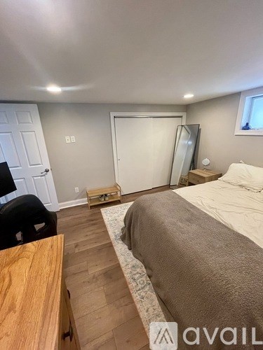 A bedroom with a bed, a desk, and a chair.