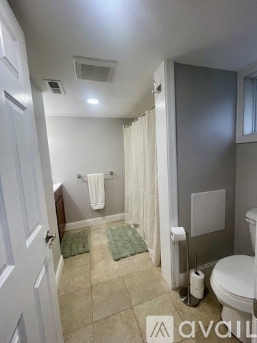 A bathroom with a toilet, a sink, and a shower curtain.