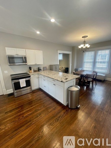 A kitchen with a wooden floor and white cabinets.