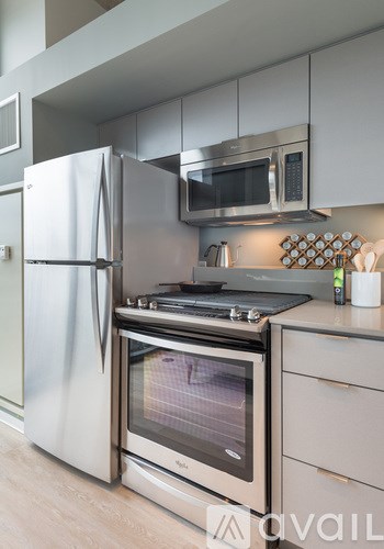 A modern kitchen with a stainless steel refrigerator and oven.