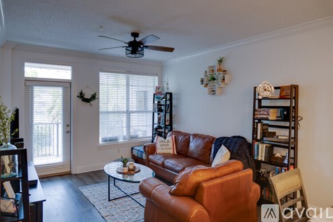 A living room with a brown leather couch and a coffee table.