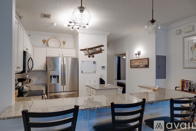 A kitchen with a marble countertop and two chairs.