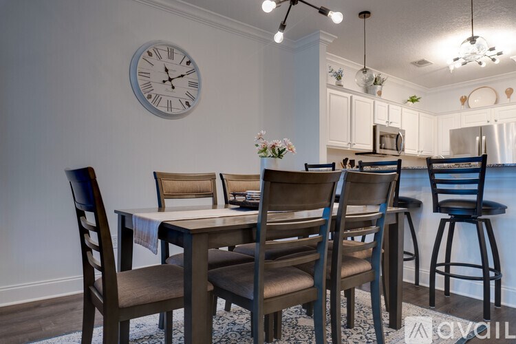 A dining room with a table and chairs.