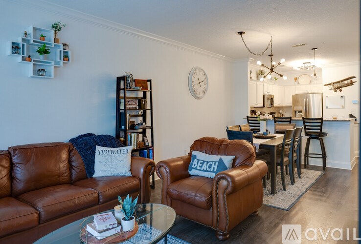 A living room with a brown leather couch and a glass coffee table.