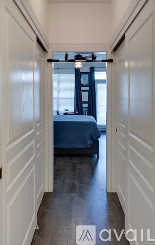 A narrow hallway with a bed on the other side.