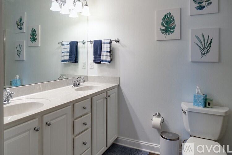 A bathroom with a sink, toilet, and a mirror.