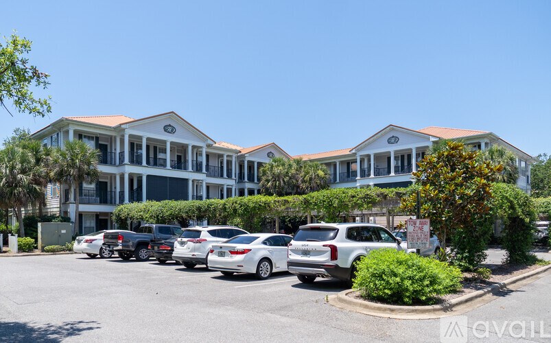 A row of parked cars in front of a building with a clear blue sky above.