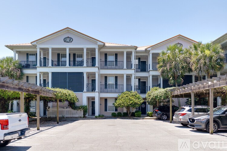 A large white building with a balcony and a logo on the front.