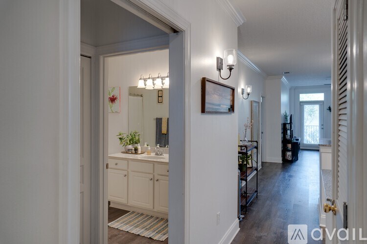 A hallway with a white wall and a framed picture hanging on it.