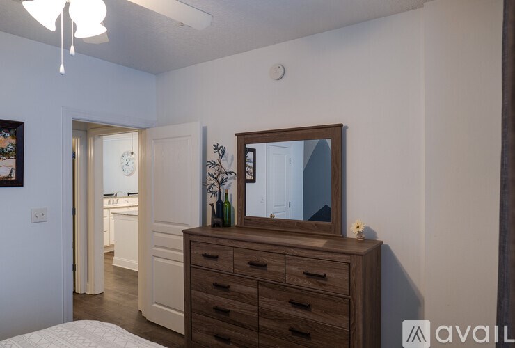 A bedroom with a dresser and mirror.