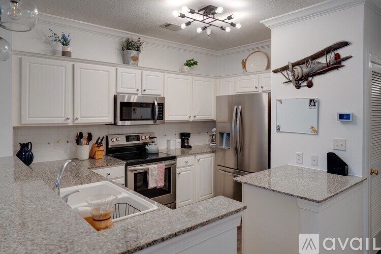 A kitchen with granite countertops and white cabinets.