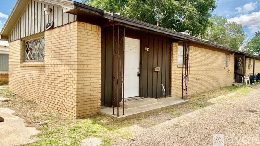 A small brick house with a white door and a window.
