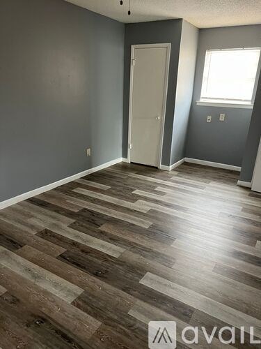 A room with wooden flooring and a door.