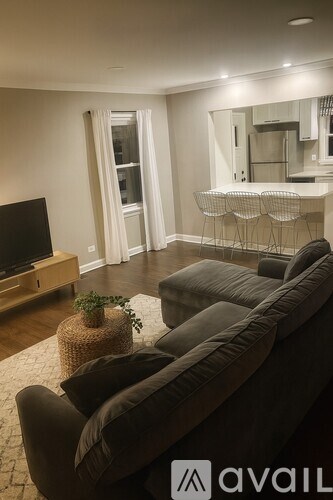 A living room with a grey sofa and a wooden entertainment center.