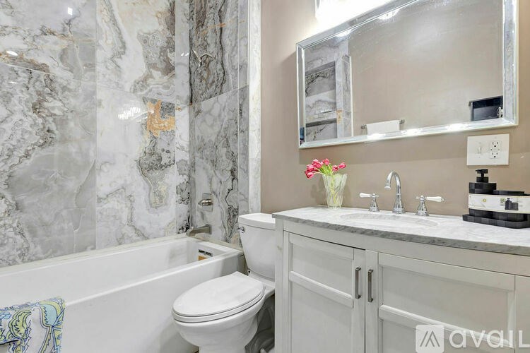 A bathroom with a marble wall and a white toilet.